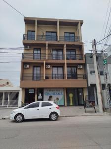 a white car parked in front of a building at Departamento bonito con balcón in La Banda