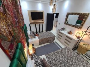 a living room with two beds and a television at DAR agafay in Lalla Takerkoust