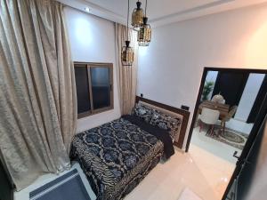 a bedroom with a bed and a large window at DAR agafay in Lalla Takerkoust
