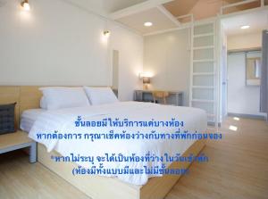 a bedroom with a white bed with blue writing on it at Barn Sampran Resort บ้านสามพรานรีสอร์ท in Nakhon Pathom