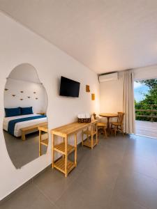 a bedroom with a bed and a desk and a table at Shalon Adonai by Martinelli Lodge in Fernando de Noronha