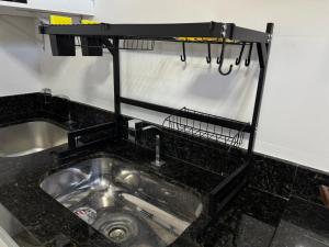 a kitchen sink with a black counter top at M e M Studio novo 201 in Ipatinga