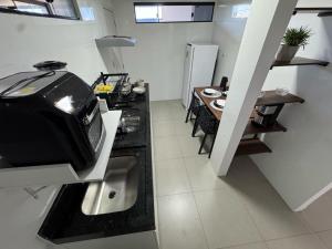a kitchen with a stove and a table in it at M e M Studio novo 201 in Ipatinga +5 photos