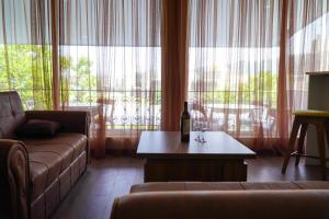 a living room with a couch and a bottle of wine on a table at Niss House2 in Akhaltsikhe