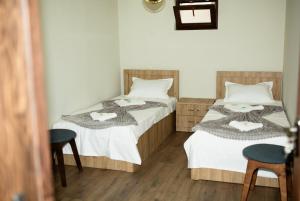 two beds in a room with two chairs at Niss House2 in Akhaltsikhe