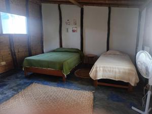 a room with two beds and a window at Guayobungalows in Máncora