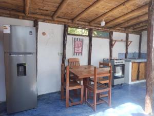 a kitchen with a wooden table and a refrigerator at Guayobungalows in Máncora