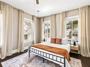 a bedroom with a bed and two windows at Sand and Sea Manor in Galveston