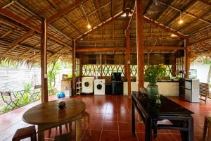 a large room with a table and a kitchen at Mango Home in Ben Tre