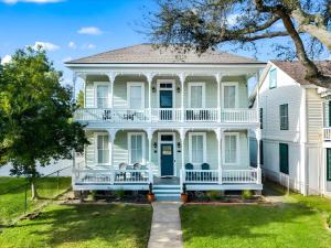 a large white house with a porch and a front yard at Sand and Sea Manor in Galveston