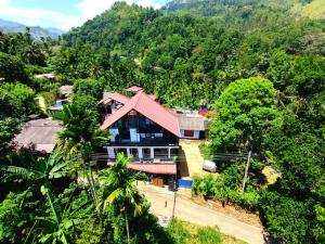 a house with a red roof on a mountain at Mountain Breeze Villa & Ayurveda Spa in Ella