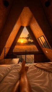 a person laying on a bed in a room with a window at Chalé Queen in Brasília +5 photos