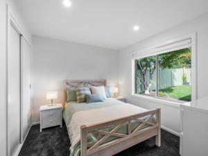 a bedroom with a bed and a large window at Links Golf Retreat in Mansfield