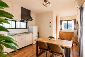 a kitchen with a wooden table and chairs at Good Stay Apartment Nichinan - Sea View & Free Parking in Nichinan
