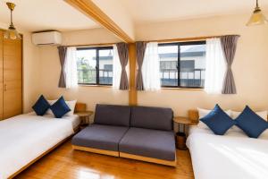 a living room with two beds and a couch at Good Stay Apartment Nichinan - Sea View & Free Parking in Nichinan