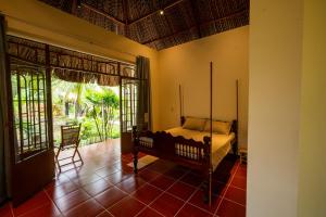 a bedroom with a bed in a room with windows at Mango Home in Ben Tre +75 photos