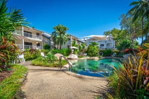 a swimming pool in front of a building at Melaleuca Resort in Palm Cove