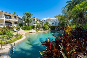 a swimming pool in front of a building at Melaleuca Resort in Palm Cove