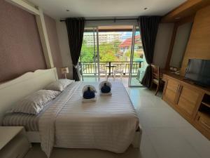 a bedroom with a bed with a television and a balcony at Jomtien Beach Penthouses in Jomtien Beach +111 photos
