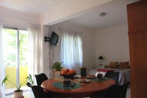 a living room with a table and a bed at A bright, centrally located apartment in Barraquero