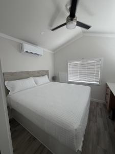 a white bedroom with a bed and a ceiling fan at Roam America Horseshoe Bend in Page