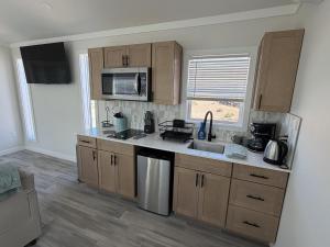 a kitchen with wooden cabinets and a sink and a microwave at Roam America Horseshoe Bend in Page