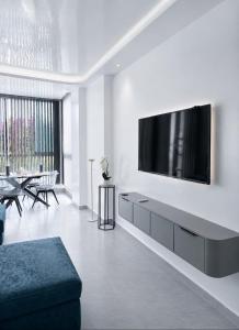 a living room with a tv on a white wall at Résidence Kariat Cabo 2-bedroom apartment in Cabo Negro