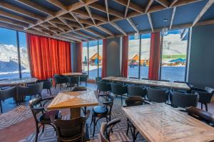 a restaurant with tables and chairs and large windows at New Gudauri Viva Seasons in Gudauri