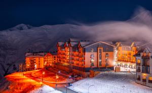 a large building in the snow at night at New Gudauri Viva Seasons in Gudauri
