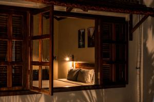 a mirror in a bedroom with a bed and a lamp at The Laneway Hostel in Xuân Sơn
