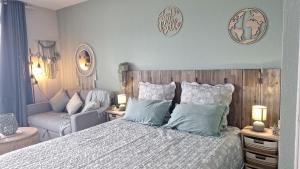 a bedroom with a bed and a couch at Pause tropicale in Le Diamant