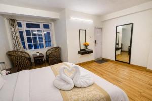a bedroom with two white swans on a bed at Hotel The Dzong ! Gangtok in Gangtok