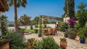 a patio with a table and chairs and plants at Babis House in Pelekas