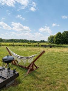 a hammock sitting on a deck in a field at Żurawi Staw- Slow Life koło Augustowa Natura i Spokój in Augustów