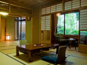 a living room with a wooden table and chairs at Ichirino Kogen Hotel Roan in Hakusan