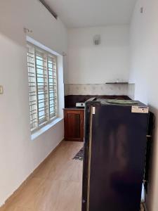 a kitchen with a refrigerator in the middle of a room at Dver Prirody in Kovalam