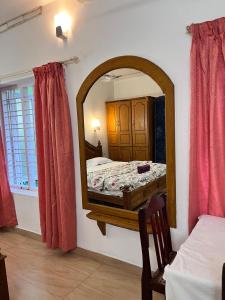a bedroom with a mirror and a bed in it at Dver Prirody in Kovalam