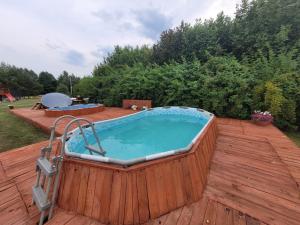 a large hot tub on a wooden deck at Żurawi Staw- Slow Life koło Augustowa Natura i Spokój in Augustów