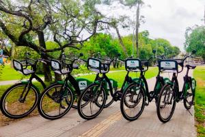 four bikes parked in a row in a park at Apartamento central bem localizado in Pelotas