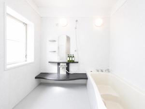 a white bathroom with a tub and a sink at simasima-stay高松駅 ー 高松駅徒歩2分 無料駐車場ー in Takamatsu