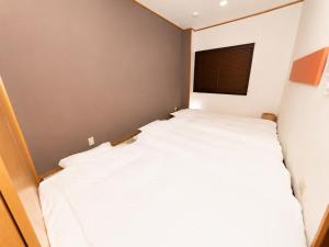 a small bedroom with a white bed in it at simasima-stay高松駅 ー 高松駅徒歩2分 無料駐車場ー in Takamatsu +45 photos