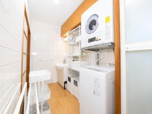 a small white bathroom with a sink and a microwave at simasima-stay高松駅 ー 高松駅徒歩2分 無料駐車場ー in Takamatsu