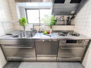 a kitchen with stainless steel appliances and a sink at simasima-stay高松駅 ー 高松駅徒歩2分 無料駐車場ー in Takamatsu