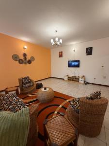 a living room with chairs and a flat screen tv at Mon havre in Yaoundé