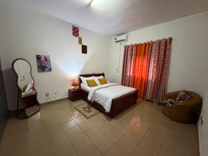 a bedroom with a bed and a chair in it at Mon havre in Yaoundé