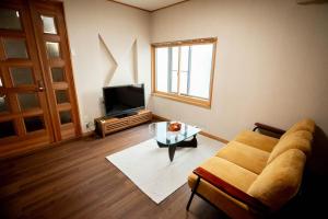 a living room with a couch and a tv at Nomachi Villa in Kanazawa