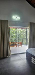 a bedroom with a bed and a view of a balcony at Royal Heaven Wayanad in Ambalavayal