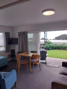 a living room with a table and chairs at Bayview Motel in Paihia