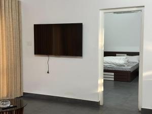a flat screen tv on a white wall in a bedroom at Royal Heaven Wayanad in Ambalavayal
