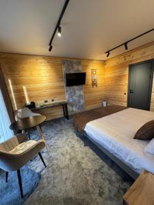 a bedroom with a bed and a desk and a chair at Zarechnoe Guest House in Tash-Tyube